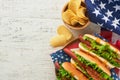 4th of July American Independence Day traditional picnic food. Hot dog with potato chips and cocktail, American flags and symbols Royalty Free Stock Photo