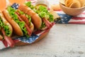 4th of July American Independence Day traditional picnic food. Hot dog with potato chips and cocktail, American flags and symbols Royalty Free Stock Photo