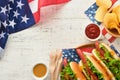 4th of July American Independence Day traditional picnic food. Hot dog with potato chips and cocktail, American flags and symbols Royalty Free Stock Photo