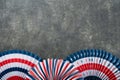 4th of July background. USA paper fans, Red, blue, white stars, balloons, gold confetti on gray dark concrete background. Happy Royalty Free Stock Photo