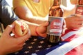 Holiday composition with multiple bottles of beer and hot dogs, American flag. Group of people celebrating Independence day of USA Royalty Free Stock Photo