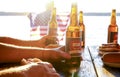 Holiday composition with multiple bottles of beer and hot dogs, American flag. Group of people celebrating Independence day of USA Royalty Free Stock Photo