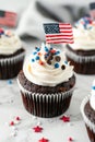 4th of july chocolate cupcakes with cream cheese and eeuu flag on top on wooden table