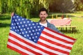 4th of July - Independence day of America. Happy man with national flag of United States having picnic in park Royalty Free Stock Photo