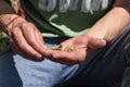 A Man putting mixture of tobacco and weed inside the Bidi for smoking.