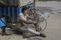 17th November, 2021, Narendrapur, West Bengal, India: A mid aged man repairing a cycle wheel in his road side shop