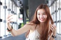 Thai adult beautiful girl using her smart phone Selfie.