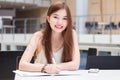 Thai adult beautiful girl write a book and smile in university.