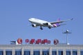 Thai Airways Airbus 330-343X skims over a building of China Aviation Oil Corporation, Beijing, China Royalty Free Stock Photo