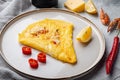 Thai Asian omelette, fresh red chilli, brown and white crabmeat, lemon, Cheddar cheese, eggs, on plate, on gray background