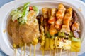 Thai beef satay on paper plate with the cucumber and peanut sauce Royalty Free Stock Photo