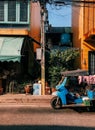 Thai blue Tuk Tuk with yellow buildings at old market in Padrew chachoengsao