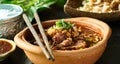 Thai bowl of beef noodle soup in clay pot with duck liver