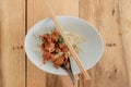 Thai Braised chicken noodle served with chopsticks on wooden table. Royalty Free Stock Photo