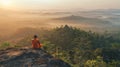 Thai buddhist monk meditating on a mountain at sunrise. Spiritual contemplation with breathtaking landscape. Concept of