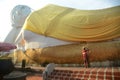 Thai Buddhists Paste gold leaf on the largest Reclining Buddha.