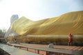 Thai Buddhists Paste gold leaf on the largest Reclining Buddha.