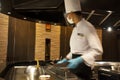 Thai chef cooking fried meat and vegetables donburi japanese food show customer before serve in modern restaurant at Bangyai city