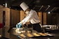 Thai chef cooking fried meat and vegetables donburi japanese food show customer before serve in modern restaurant at Bangyai city