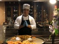 Thai chef in a suit folded his hands Namaste, he prepares a national dish of seafood, rice noodles and sprouted grains