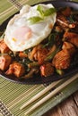 Thai chicken with basil, green beans and a fried egg on a plate