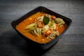 Thai chicken spicy tom yum soup with wooden background