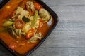 Thai chicken spicy tom yum soup with wooden background