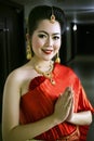 Thai Chinese lady in red dress greeting welcome