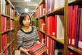 Thai college girl is holding stack of books