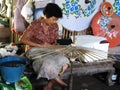 Thai craftsmanship technician drawing painting color on handmade paper umbrella for show and sale in studio workshop at Bo Sang or