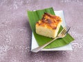 Thai custard cake on banana leaf and spoon on white plate with stone background Royalty Free Stock Photo