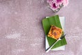 Thai custard cake on banana leaf and spoon on white plate with stone background Royalty Free Stock Photo