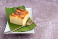 Thai custard cake or Khanom mo kaeng in Thai on banana leaf and spoon on a white plate with a stone background. Egg custard with Royalty Free Stock Photo