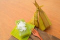 Thai dessert sticky rice wrapped in banana leaf on wood background Royalty Free Stock Photo