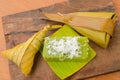 Thai dessert sticky rice wrapped in banana leaf on wood background. Royalty Free Stock Photo