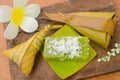 Thai dessert sticky rice wrapped in banana leaf on wood background Royalty Free Stock Photo