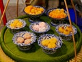 Thai desserts in a ceramic bowls placed and displayed on a portable tray made of banana leaf