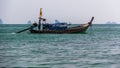 Thai dinghy against the backdrop of limestone cliffs.