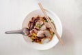 Thai egg noodle in white bowl with sliced red barbecue pork, pork ball, fish sausages top view on white background Royalty Free Stock Photo