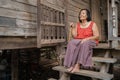 Thai elderly woman in round-necked sleeveless collar sitting lonely in wooden home