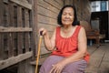 Thai elderly woman in round-necked sleeveless collar sitting lonely in wooden home