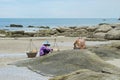 Thai elderly woman in traditional straw hat with heavy large baskets sells fresh fruits to lonely tourist with tattoo.