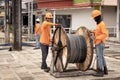 Thai electrician workers unwrap a bay with a cable on the street. Laying of new power grids of cables and wiring