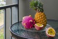 Thai exotic fruits pineapple, dragonfruit, passion fruit on a glass table