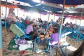 Thai family eating lunch seated at beach