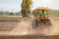 Thai farmer on big tractor in the land to prepare the soil for rice season