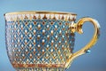 Thai fine art traditional five colors (Bencharong) tea cup over blue blurry background.