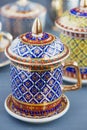 Thai fine art traditional five colors (Bencharong) tea cup over blue blurry background.