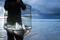 Thai fisherman holding a shoal of big Common Silver barb in a fish net