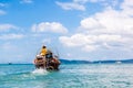 Thai fisherman sailing in the sea on a long-tail boat. To fish. On the background of the yacht and cruise liner. Coast province Royalty Free Stock Photo